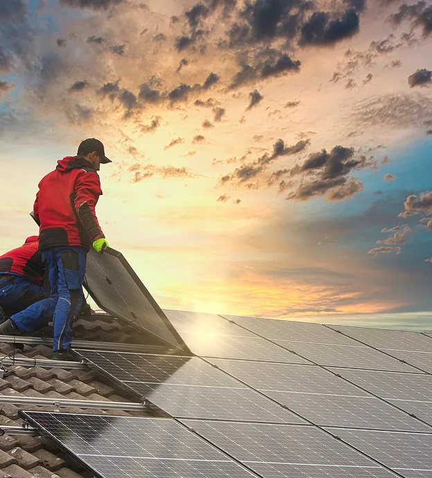 Installateurs travaillant sur un toit, posant des panneaux solaires sous un ciel nuageux à Vauréal dans le Val-d’Oise 95